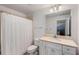 Bright bathroom featuring a white vanity, shower with white curtain, and large mirror at 980 Faith Se Ave, Atlanta, GA 30316