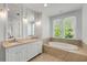 Bright bathroom with a large soaking tub with tiled surround by a window and a double vanity at 980 Faith Se Ave, Atlanta, GA 30316