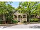 Charming home with a covered front porch, decorative railings, lush trees, and beautiful architectural details at 980 Faith Se Ave, Atlanta, GA 30316