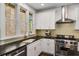 Modern kitchen featuring stainless steel appliances, white cabinets, gold hardware, and brick-framed windows at 980 Faith Se Ave, Atlanta, GA 30316