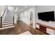 Open-concept living room with dark wood floors, a staircase, and a large mounted television at 980 Faith Se Ave, Atlanta, GA 30316