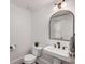 Stylish powder room with a pedestal sink, decorative mirror, and modern fixtures at 980 Faith Se Ave, Atlanta, GA 30316