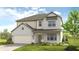 Charming two-story home features a brick and siding exterior, attached two-car garage, and manicured lawn at 1734 Fawlocke Run, Loganville, GA 30052