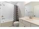 Bright bathroom featuring white subway tile, shower-tub, gray-patterned shower curtain and single sink vanity at 1964 Attell Way, Decatur, GA 30033
