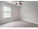 A bright bedroom features neutral walls, carpet, and trim, a ceiling fan, and a window for natural light at 1964 Attell Way, Decatur, GA 30033