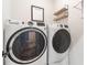 A laundry room features modern appliances including a washer and dryer, floating shelves, and gray walls at 1964 Attell Way, Decatur, GA 30033