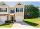 Charming townhome featuring a well-manicured lawn and a private garage, complete with classic architectural accents at 5525 Sable Way, Atlanta, GA 30349
