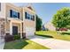 Inviting townhome showcasing a neatly kept lawn, private garage, and a classic facade under a clear, sunny sky at 5525 Sable Way, Atlanta, GA 30349