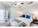 Well-lit main bedroom featuring a large bed with an accent wall, tray ceilings and ceiling fan at 5525 Sable Way, Atlanta, GA 30349