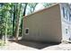 Side exterior view with neutral siding, a chainlink fence, and tree cover at 5561 Petite Pt, Lithonia, GA 30058