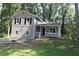 Charming two-story home with a covered porch and neutral siding surrounded by lush trees at 5561 Petite Pt, Lithonia, GA 30058