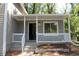 Inviting covered front porch with white railing and steps leading to the entrance at 5561 Petite Pt, Lithonia, GA 30058