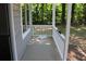 Covered porch with railing overlooking a wooded area, offering a peaceful outdoor space at 5561 Petite Pt, Lithonia, GA 30058
