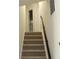 Carpeted stairs leading to the second level with wood railing at 5561 Petite Pt, Lithonia, GA 30058