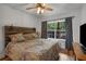 Bedroom with decorative wood headboard, ceiling fan, and natural light at 6980 Roswell Rd # B13, Sandy Springs, GA 30328