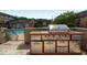 Outdoor kitchen area with a stainless steel grill and a built-in prep station near a refreshing pool at 6980 Roswell Rd # B13, Sandy Springs, GA 30328