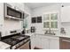 Well-lit kitchen featuring stainless steel appliances, white cabinets, subway tile backsplash, and hardwood floors at 205 3Rd Street Northeast Ne St # 4, Atlanta, GA 30308