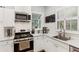 Well-lit kitchen featuring stainless steel appliances, white cabinets, marble countertops, and hardwood floors at 205 3Rd Street Northeast Ne St # 4, Atlanta, GA 30308