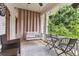 Inviting outdoor porch with swing, wicker furniture, curtains, and view of the surrounding greenery at 205 3Rd Street Northeast Ne St # 4, Atlanta, GA 30308