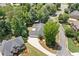 Overhead view of a home with a three-car garage, situated in a neighborhood with mature trees and landscaping at 997 Thousand Oaks Nw Bnd, Kennesaw, GA 30152