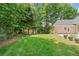 Green backyard with mature trees and a brick home exterior at 997 Thousand Oaks Nw Bnd, Kennesaw, GA 30152