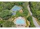 Aerial view of the community amenities including a pool, tennis courts, playground and a surrounding wooded area at 997 Thousand Oaks Nw Bnd, Kennesaw, GA 30152