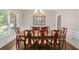 Formal dining room featuring a large wooden table, stylish chairs, and natural light from a window at 997 Thousand Oaks Nw Bnd, Kennesaw, GA 30152
