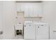 Functional laundry room with white cabinets, sink, and modern washer and dryer at 997 Thousand Oaks Nw Bnd, Kennesaw, GA 30152