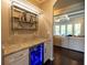 Bar area that leads to living room with under counter fridge and decorative glass racks at 3589 Tamerton Trce, Buford, GA 30519