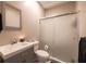 Cozy bathroom featuring a vanity with a grey cabinet, a toilet, and a shower with a frosted sliding door at 3589 Tamerton Trce, Buford, GA 30519