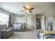 Cozy bedroom with plush carpet, soft gray walls, ceiling fan, and a comfortable seating area at 3589 Tamerton Trce, Buford, GA 30519