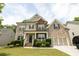 Charming two-story brick home with a welcoming front porch and well-manicured landscaping on a sunny day at 3589 Tamerton Trce, Buford, GA 30519