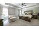 Large main bedroom with plush carpet, neutral decor, a seating area, and lots of natural light from the windows at 3589 Tamerton Trce, Buford, GA 30519