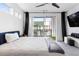 Bright bedroom with light colored carpet, dark curtains, with a TV on the wall at 395 Pratt Drive Se # No 802, Atlanta, GA 30315