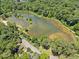 Scenic aerial view of the community lake surrounded by lush greenery and trees at 4614 Ridge Dr, Pine Lake, GA 30072