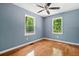 Bedroom featuring hardwood floors, neutral paint, a ceiling fan, and natural light from two windows at 4614 Ridge Dr, Pine Lake, GA 30072