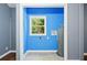 Efficient laundry room with blue walls, tile floor, and a window providing natural light at 4614 Ridge Dr, Pine Lake, GA 30072