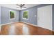 Living room features hardwood floors, neutral paint, ceiling fan, and natural light from two windows at 4614 Ridge Dr, Pine Lake, GA 30072