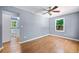 Bright primary bedroom with hardwood floors, ceiling fan, ensuite bath, and natural light at 4614 Ridge Dr, Pine Lake, GA 30072