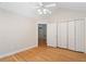 Bright bedroom featuring hardwood floors, a ceiling fan, and a spacious closet with white folding doors at 5336 Stone Village Nw Cir # 2, Kennesaw, GA 30152