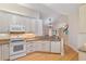 Bright kitchen features white appliances, white cabinets, granite counters and hardwood floors at 5336 Stone Village Nw Cir # 2, Kennesaw, GA 30152