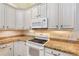 Bright kitchen featuring white appliances, white cabinets, and granite countertops at 5336 Stone Village Nw Cir # 2, Kennesaw, GA 30152