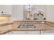 Double stainless steel sink with granite countertops, white cabinets, and view to the living room at 5336 Stone Village Nw Cir # 2, Kennesaw, GA 30152