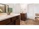 Modern bathroom with double sinks, stone floors, and a separate soaking tub at 121 Royal Sunset Dr, Dallas, GA 30157