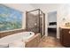 Elegant bathroom with a soaking tub, glass shower, and serene view of the outdoors at 121 Royal Sunset Dr, Dallas, GA 30157