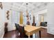 Formal dining room featuring hardwood floors, coffered ceiling, elegant chandelier, and wainscoting at 121 Royal Sunset Dr, Dallas, GA 30157