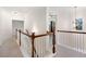 Bright upstairs hallway with wooden rails and natural light from the window at 121 Royal Sunset Dr, Dallas, GA 30157