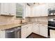 Corner of kitchen featuring white cabinets, granite countertops, stainless steel appliances, and hardwood floors at 121 Royal Sunset Dr, Dallas, GA 30157