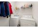 Practical laundry room equipped with a washer, dryer, shelving, and hanging racks for clothing at 121 Royal Sunset Dr, Dallas, GA 30157