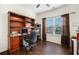 Inviting office space with a built-in desk, ample shelving, hardwood floors, and natural light from the window at 121 Royal Sunset Dr, Dallas, GA 30157